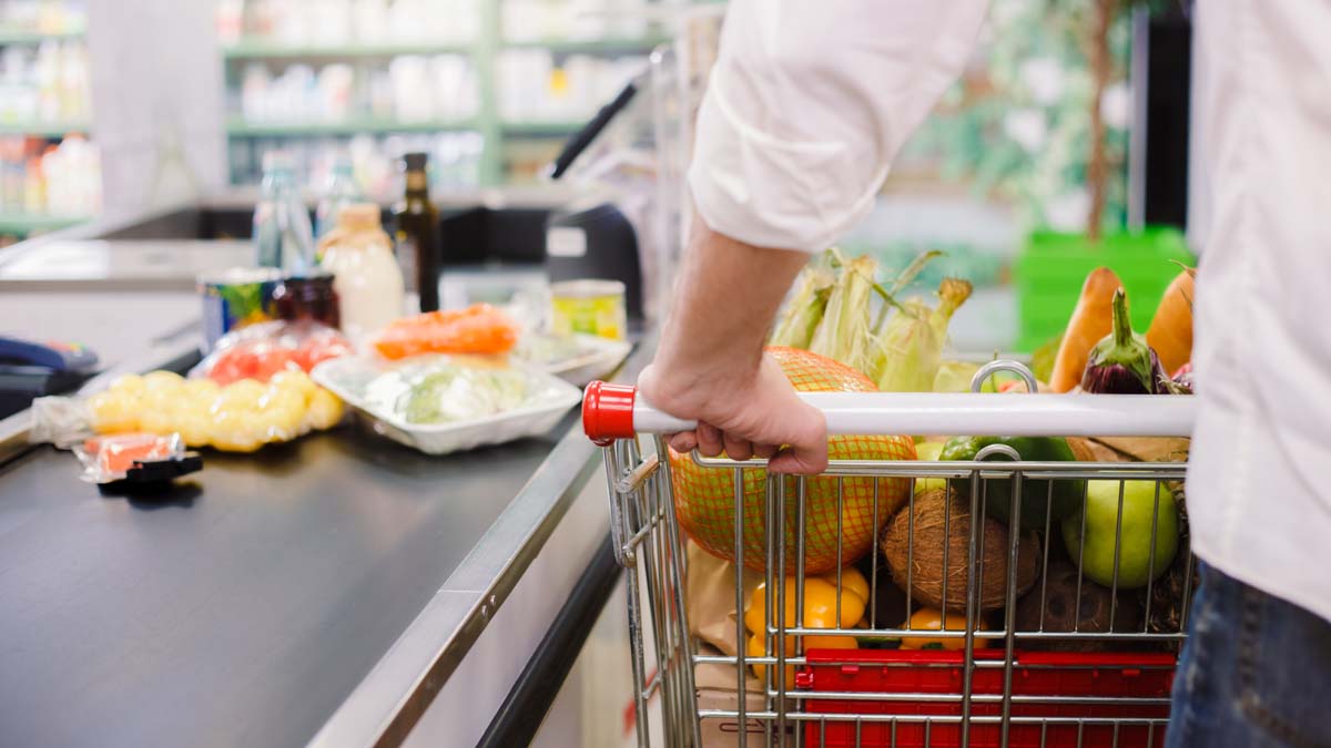 Person buying food products in the supermarket queue
